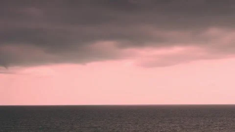 Time lapse of dramatic pink sunset sky with rain storm black thunderclouds over  動画素材 331811769