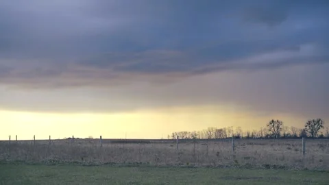 Time lapse of dramatic rain clouds in countryside over a field in autumn, winter Stock Footage 238034804