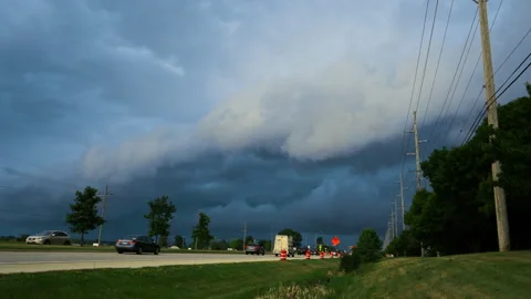 Time lapse of a dramatic shelf cloud advancing over a busy roadway as vehicles Video stock 340540512