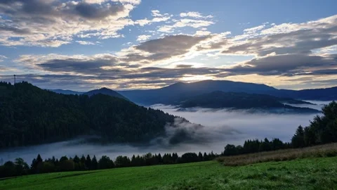Time-lapse of a Dramatic Sunrise Over a Fog-Covered Mountain Valley Stock-Footage 317813924