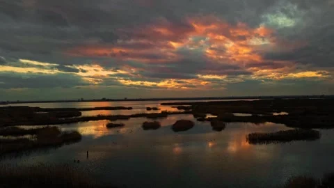 Time lapse of dramatic sunset clouds reflecting on calm wetlands Stock Footage 346426358