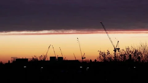 Time lapse of dramatic sunset with construction cranes Stock Footage 147532165