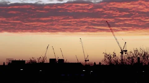 Time lapse of dramatic sunset with construction cranes Stock Footage 147532168