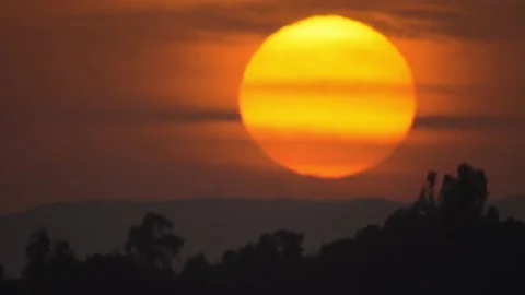 Time-lapse of dramatic sunset with sun hiding behind mountain Stock Footage 148242076