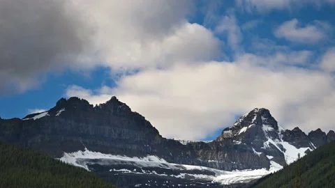 Time lapse of dramatic white and grey clouds churning above rugged mountains Stock Footage 172373494
