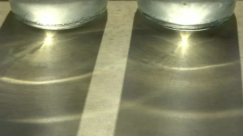 Time lapse of a drinking glass with a slow moving shadow and caustic light ef Stock Footage