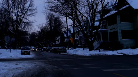 Time lapse: Dusk at a bustling intersection, with snow, cars and bright sunset Stock Footage 34334931