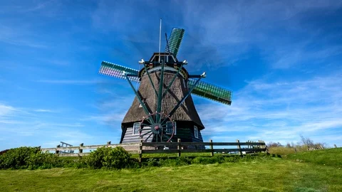 Time-lapse of a Dutch windmill. The wind mill stands on a small grass Stock Footage 97827647