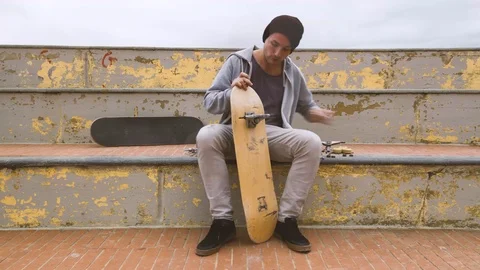 Time lapse effect of a guy assembling a professional skateboard step by step. Stock Footage 125744934