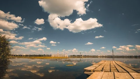 Time lapse of electrical power plant and fast moving clouds reflected in river Stock Footage 92274115