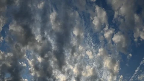 Time-lapse of evening clouds, illuminated by the setting sun, drifting across a Stock Footage 314999004
