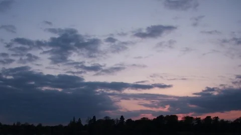Time lapse of evening clouds rolling past as sun sets and colors of the sky grad Stock Footage 75177683
