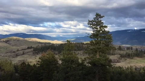 Time-lapse evening to night of dramatic clouds and sunlight over broad valley Stock Footage 88480514