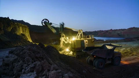 Time lapse of excavator loading ore into dump-trucks at night. This area has Stock Footage 75407357