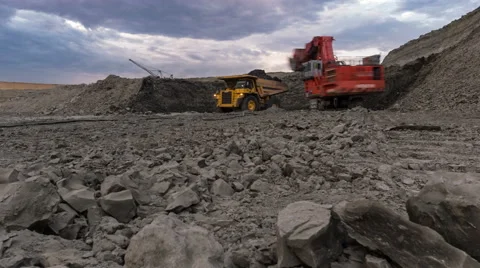 Time lapse. Excavator loads ore into dump-track. Grey rocks. Sun rays throgh the Video stock 64510824