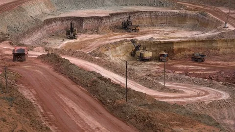Time lapse. Excavators load ore into dump-trucks. This area has been mined for Stock Footage 75587070