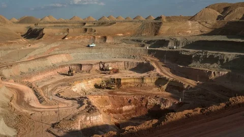 Time lapse. Excavators load ore into dump-trucks. This area has been mined for Stock Footage 75587248
