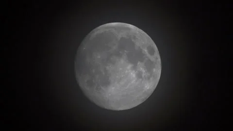 Time lapse of an extreme large full moon as it rises in the bight sky with black Stock Footage 92017369