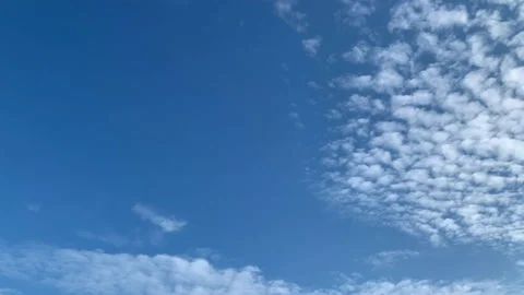 Time lapse of faint, high puffy clouds disappearing into blue sky Stock Footage 144520107