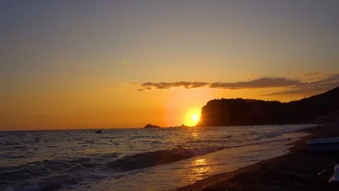 Time lapse of fascinating sunset behind a rock at sea 4K Stock Footage 118085878