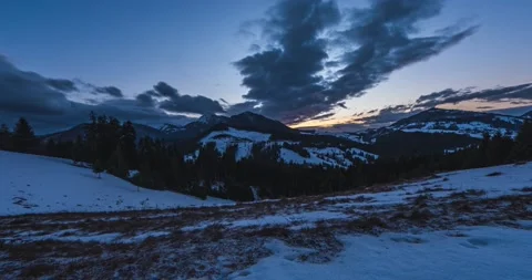 Time lapse of fast clouds sky over winter alps mountains landscape after sunset Stock Footage 239535624