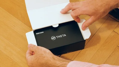 Time lapse fast motion Man unboxing new Ricoh Theta V 4k 360 degree camera Stock-Footage 101715831