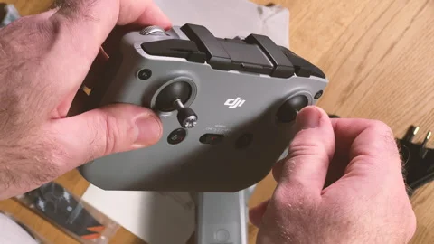 A time-lapse, fast-motion POV of a male hand unboxing a new DJI Air 2S drone, Stock Footage 255585817