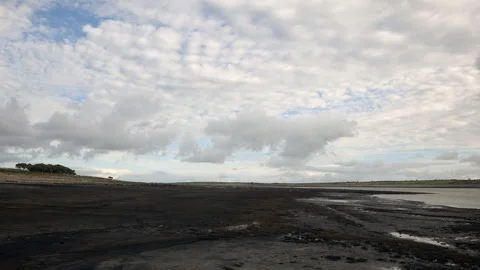 Time lapse of fast moving clouds over a reservoir with low water levels Stock Footage 219489482