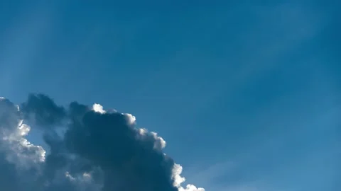 Time Lapse of Fast Moving Clouds and Rays of Sun Against Blue Sky Background Stock Footage 231695369