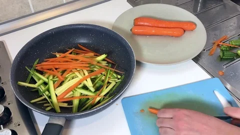 Time lapse of female hands make slices of carrots and zucchini. Vídeos de archivo 79853660