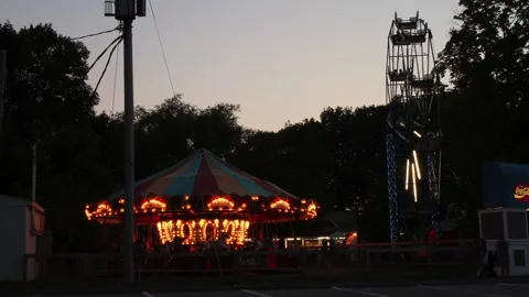 A time-lapse of a Ferris wheel and carousel at an amusement park. Stock Footage 147954325