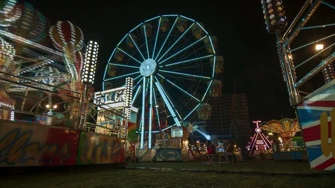Time lapse of Ferris Wheel spinning on street fun fair at night with crowd Stock Footage 101067664