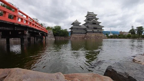 Time Lapse of fish pond with red bridge and Matsumoto castle in back, Japan Stock Footage 146141949