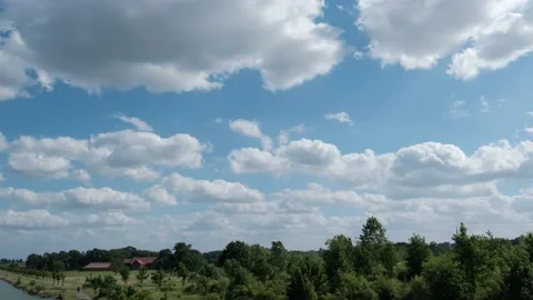 Time Lapse. Floating white clouds against beautiful trees and shrubs on a sunny Stock Footage 196855285