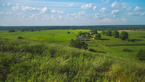 TIME LAPSE Fluffy air clouds quickly move over the chic green fields Stock Footage 80142422