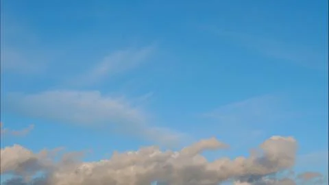 Time lapse Fluffy clouds float across the blue sky. UltraHD stock footage Stock Photos