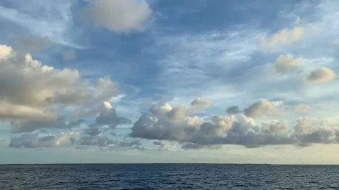 Time Lapse of fluffy clouds flying over the sea at sunset time. Stock Footage 190371464