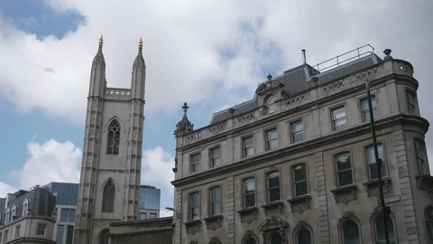 Time lapse. Fluffy clouds moving over an old tower and an apartment building. Stock Footage 107940835