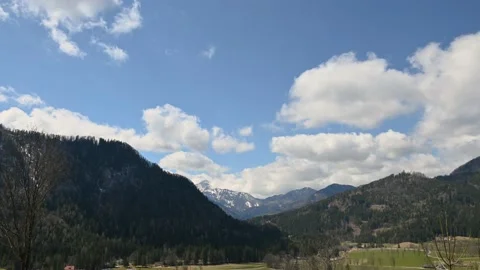 Time lapse of fluffy clouds moving above beautiful landscape in Austria Stock Footage 192495719