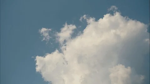 Time lapse of fluffy moving clouds running across the blue sky. Video stock 107855110