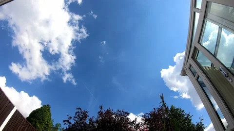 Time-lapse of fluffy white clouds drifting across a clear blue sky 스톡 동영상 220136449