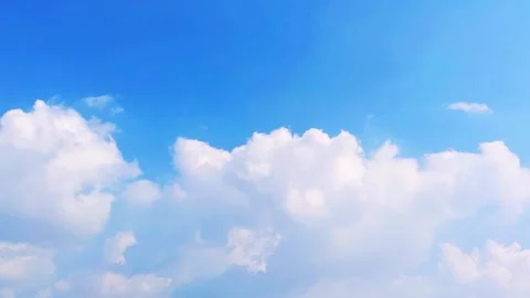 Time-lapse of fluffy white clouds moving across a bright blue sky Stock Footage 332727482