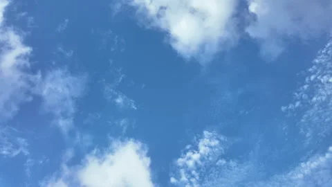 Time lapse of fluffy white clouds moving fast across bright blue sky Stock Footage 340253352