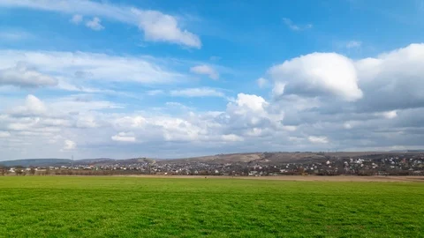 Time lapse with flying white clouds over green fields Stock Footage 125451540