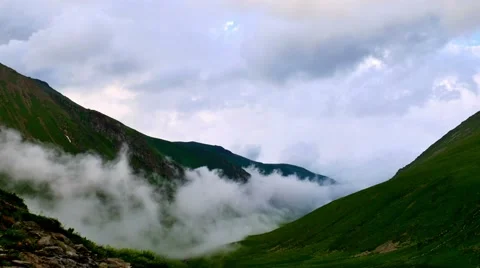 Time lapse of fog and clouds rolling over the mountain green hills 스톡 동영상 65763889