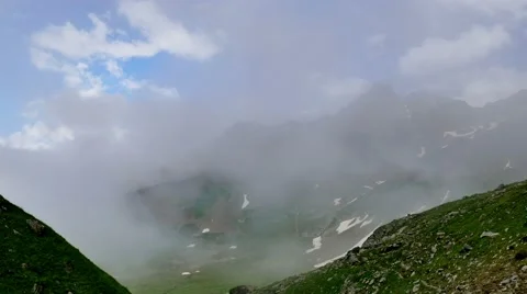 Time lapse of fog and clouds greatly reduce visibility in high mountain green Stock Footage 65764212