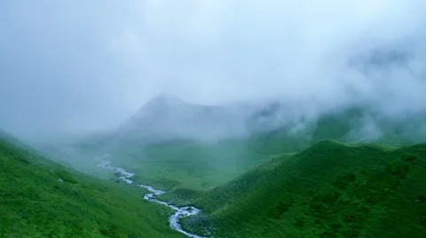 Time lapse of fog and clouds greatly reduce visibility in high mountain green Vídeos de archivo 65775606