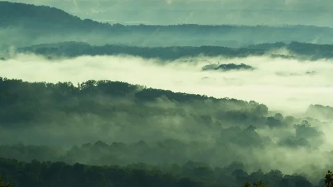 Time-lapse of fog floating over the mountain ranges at sunrise Stock-Footage 103826866