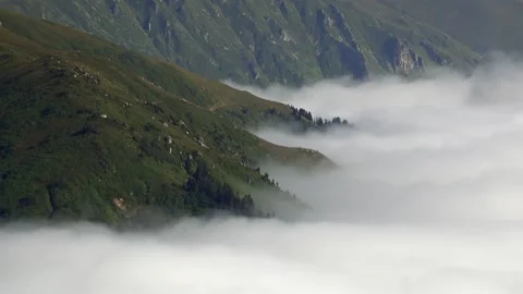 Time lapse fog flows over treeless mountain ridge - Cloud Motion and Sky Clouds Stock Footage 339699112
