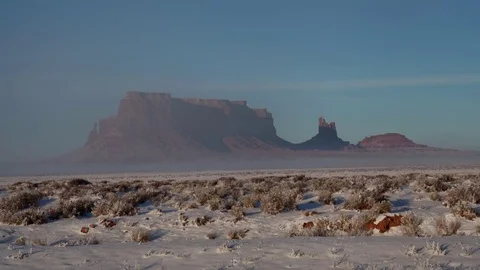 Time lapse of fog obscuring the view of sunny snow covered mesa rock formations Stock Footage 73816298
